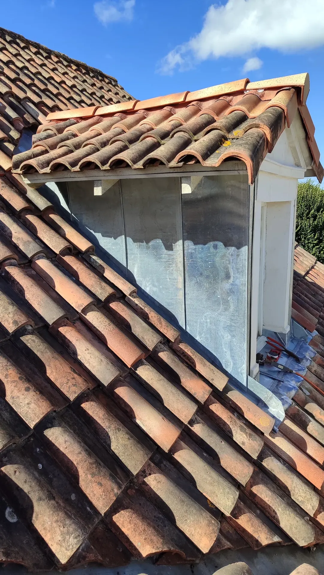 Lucarne habillée de zinc sur une toiture en tuiles