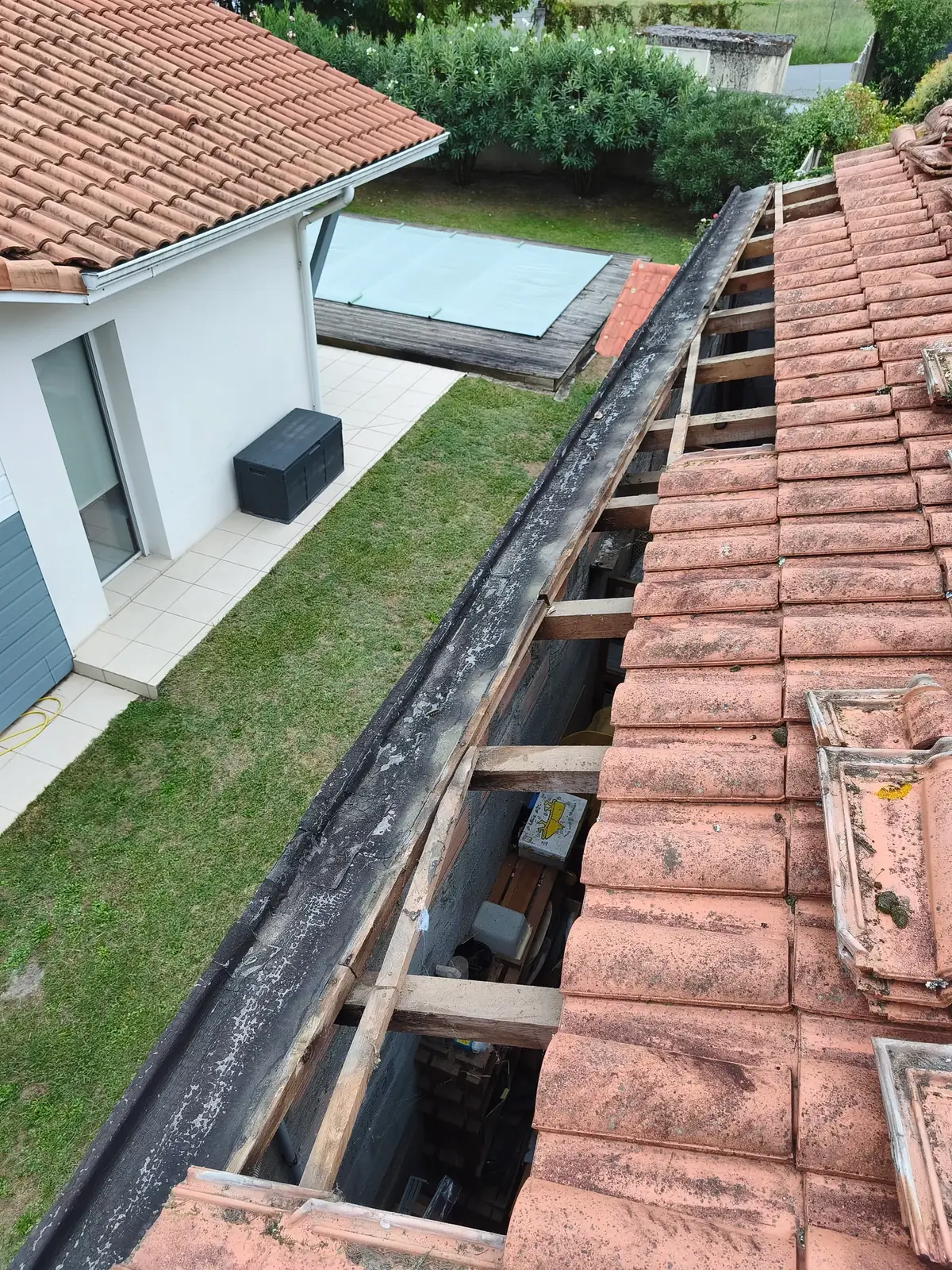 Rang de tuiles déposé sur une toiture abîmée, avant réparation
