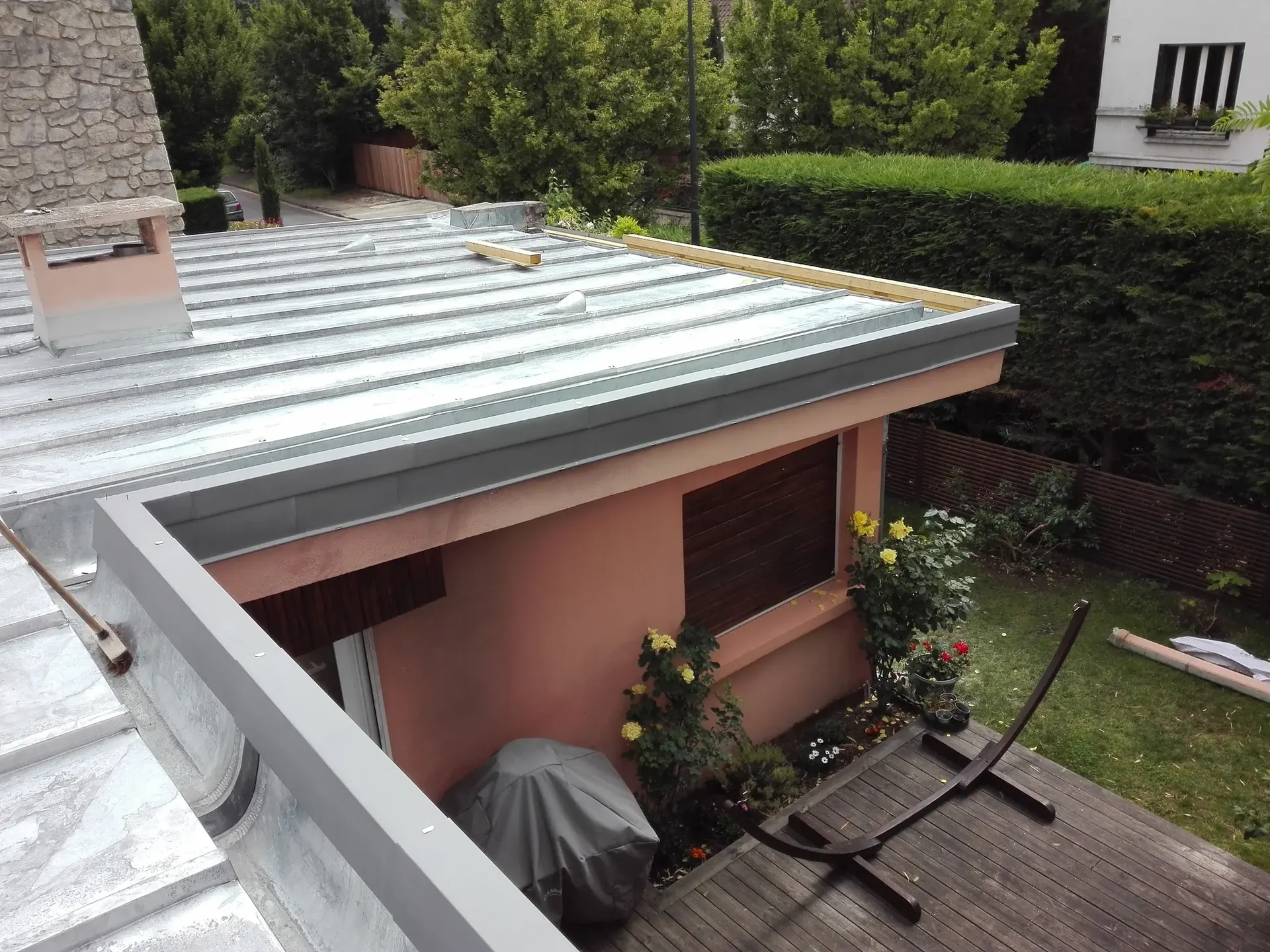 Toiture en zinc à joints debout au-dessus d'une maison avec jardin